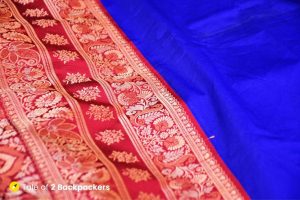 A blue and red coloured Banarasi saree displayed in shops